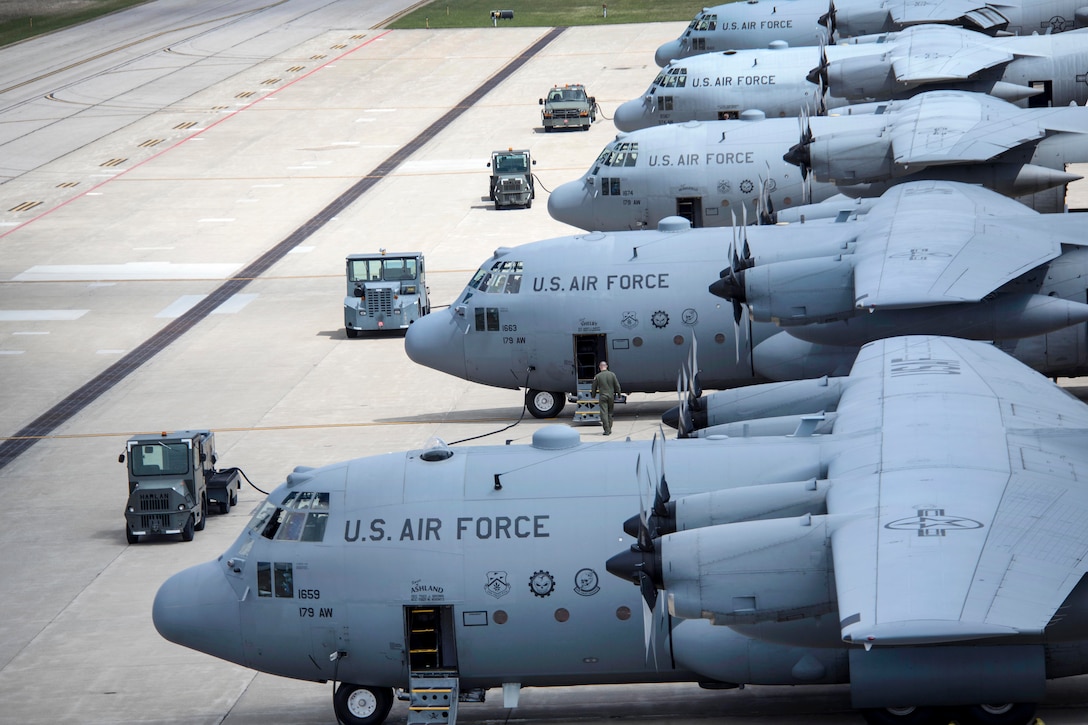 Air Force pilots and crew chiefs prepare five C-130H Hercules aircraft.