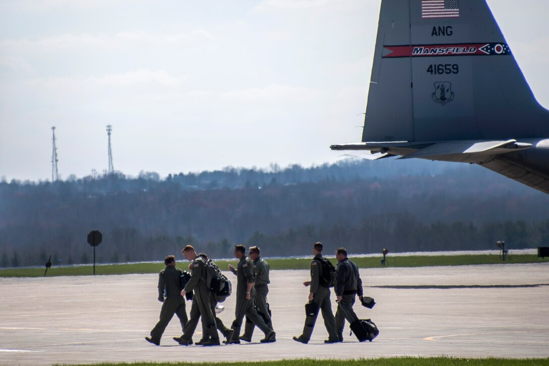 Air Force pilots walk toward the air traffic control tower.
