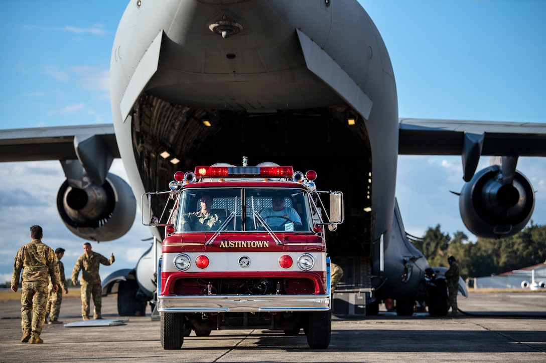 Airmen offload a fire truck from a C-17 Globemaster III.