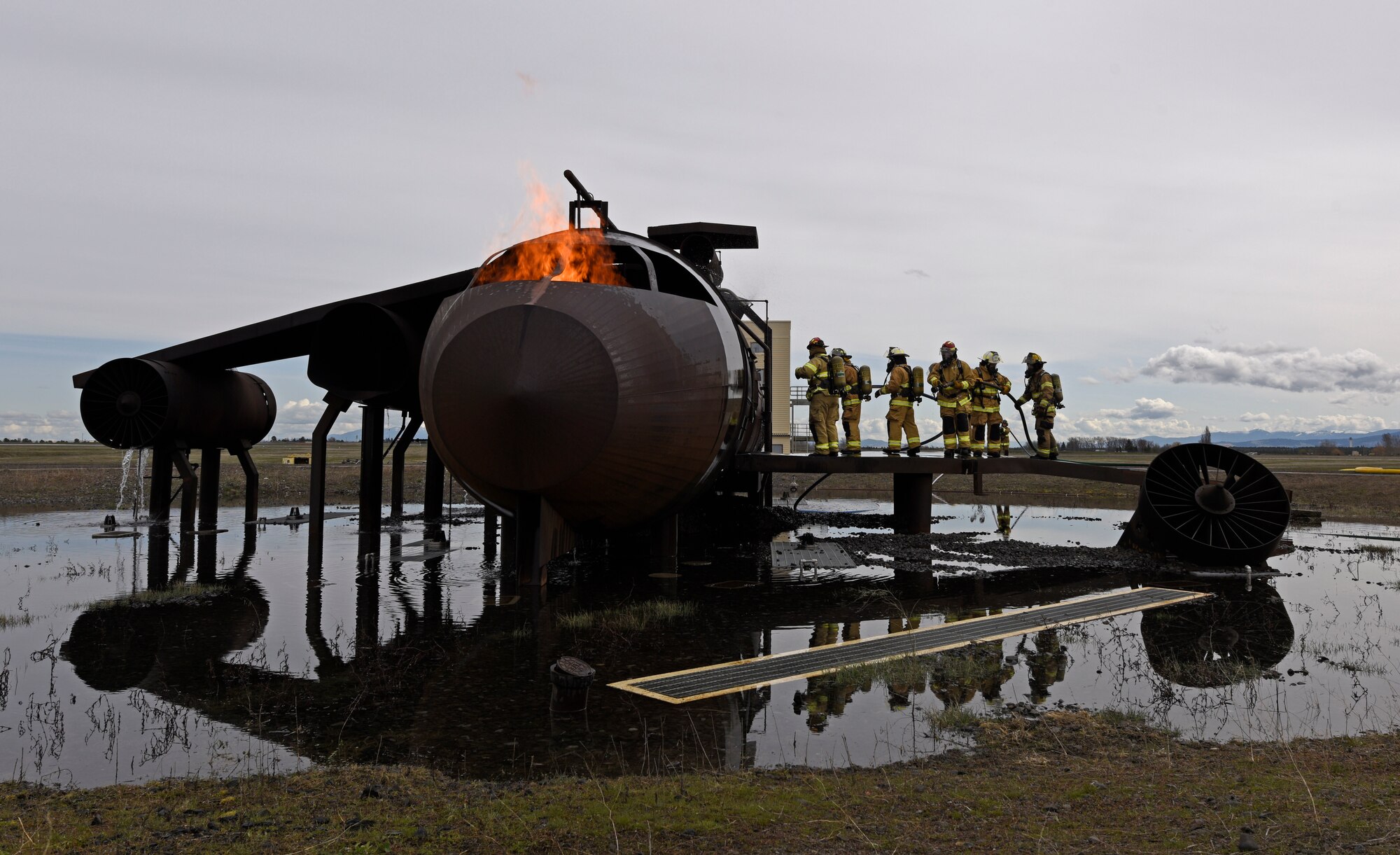 Oregon Air National Guard Airmen from Kingsley Field and civil engineer officers from various locations across the U.S. walk into an aircraft’s interior during a live fire training at Fairchild Air Force Base, Washington, April 18, 2018. The rigorous hands-on training consists of aircraft and structure live-fire scenarios. This gave both groups training in all aspects of firefighting such as emergency mitigation, prevention, communications, health, safety and mutual aid support to their local communities. (U.S. Air Force photo/Airman 1st Class Jesenia Landaverde )