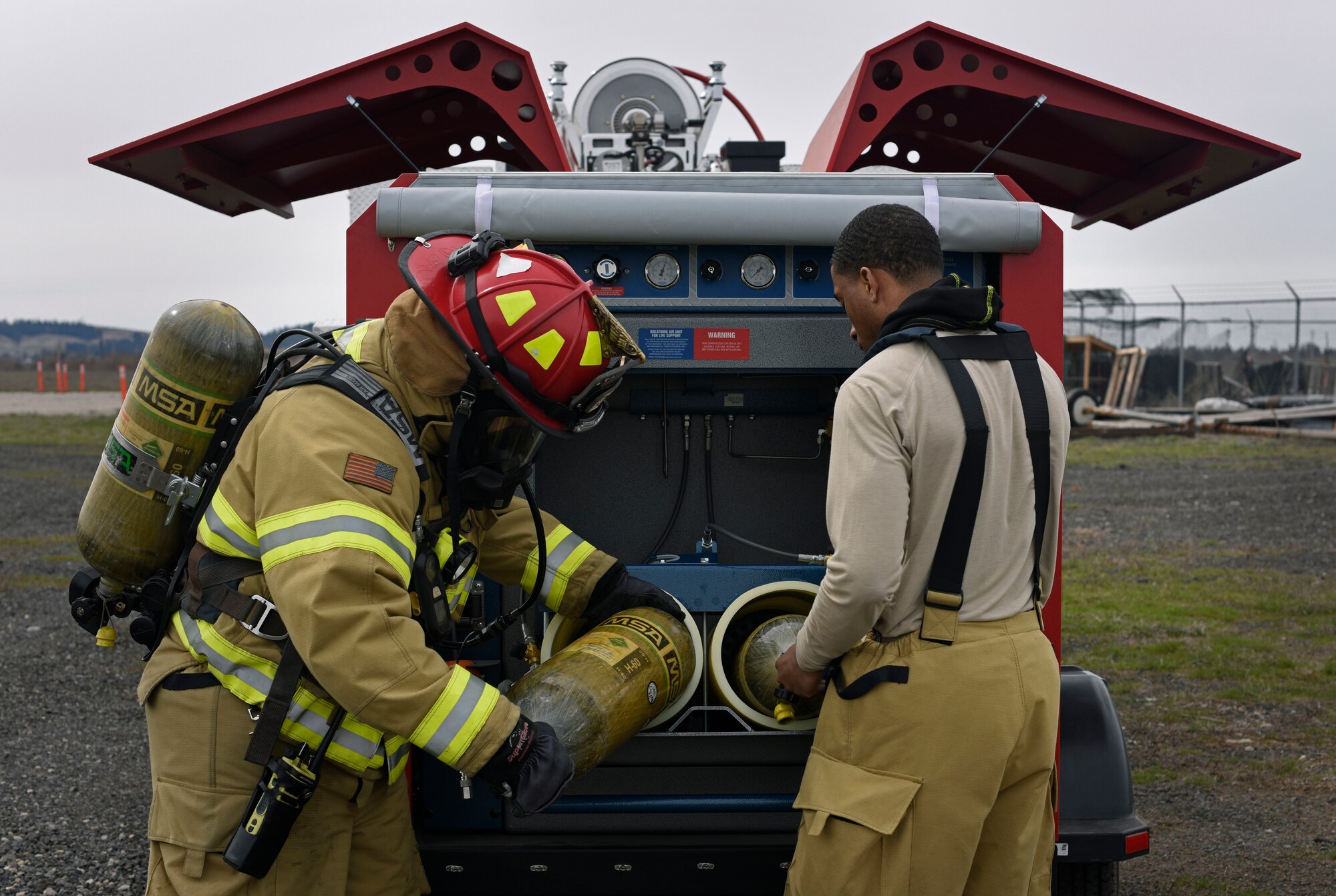 Senior Airman Jonathan Jones, 92nd Civil Engineer Squadron Fire Department firefighter, refills a self-contained breathing apparatus during a simulated aircraft live fire at Fairchild Air Force Base, Washington, April 18, 2018. The 92nd CES Fire Department coordinated and facilitated the classroom and hands-on portions of this joint service fire training and fire marshal training course. (U.S. Air Force photo/Airman 1st Class Jesenia Landaverde)