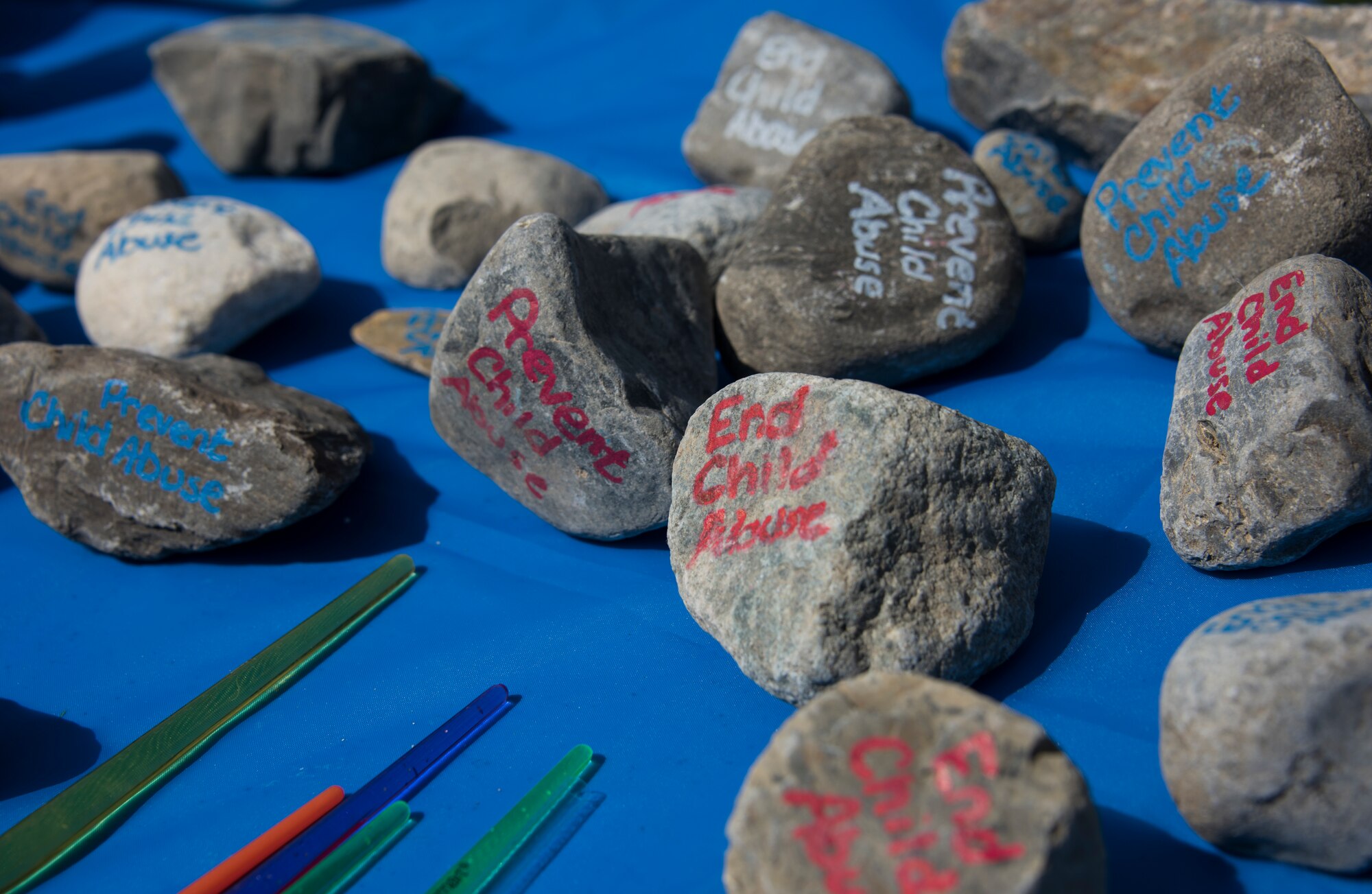 Rocks lie on a table during the Kids on Wheels Parade on Joint Base McGuire-Dix-Lakehurst, N.J., April 28, 2018. The rocks were a part of an arts and crafts station for children of the Joint Base MDL community to paint in support of child abuse prevention. The parade was a family-friendly event for parents and their children to be more aware of child abuse and understand how to prevent it. (U.S. Air Force photo by Airman Ariel Owings)