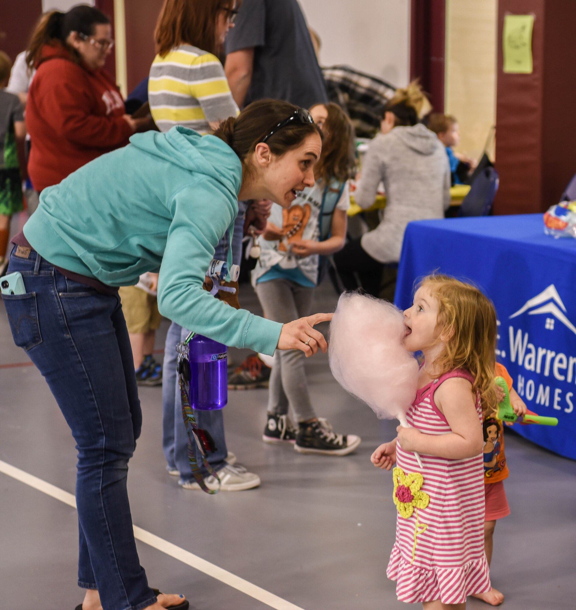 A mom gives her child cotton candy during the Month of the Military Child Spring Bash April 27, 2018, on F.E. Warren Air Force Base, Wyo. Cotton candy was just one of the many treats provided for the children by the youth center staff. The 90th Force Support Squadron held this spring bash to celebrate the children of military members and what they experience.  (U.S. Air Force photo by Airman 1st Class Braydon Williams)