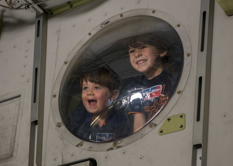 Jameson Noon and Jack Noon, sons of U.S. Air Force Tech. Sgt. Nova Noon, a NCO in charge of the publications office assigned to the 97th Training Squadron, look out a window inside a C-17 Globemaster III, April 26, 2018, at Altus Air Force Base, Okla.