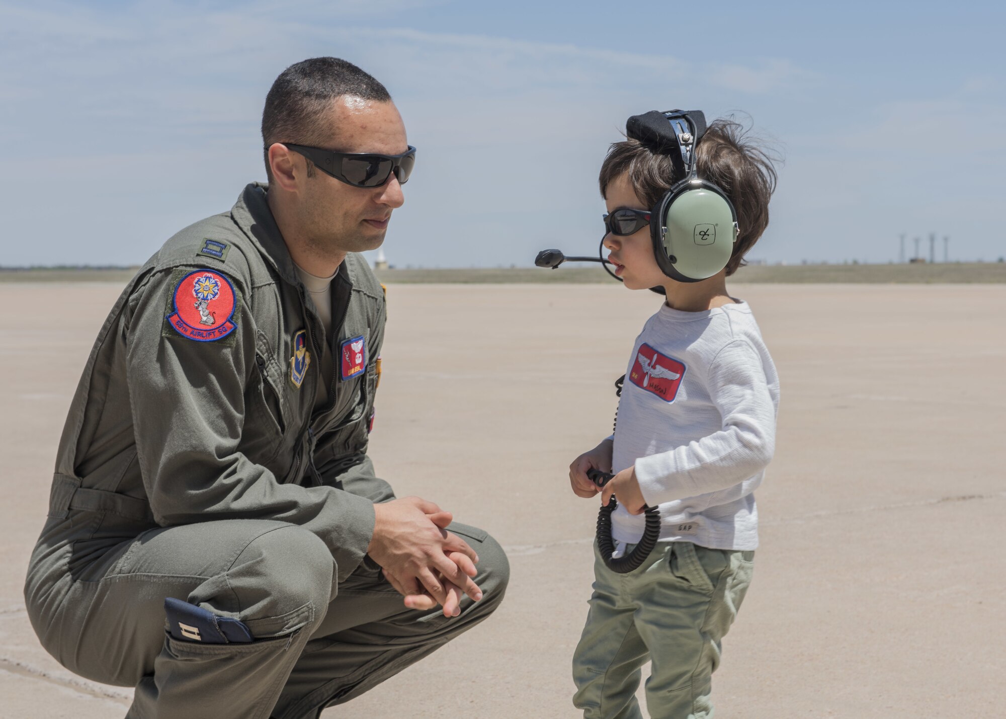 U.S. Air Force Capt. Liam Stein, the chief of student training assigned to the 58th Airlift Squadron, lets his son try on his headset, April 26, 2018, at Altus Air Force Base, Okla.