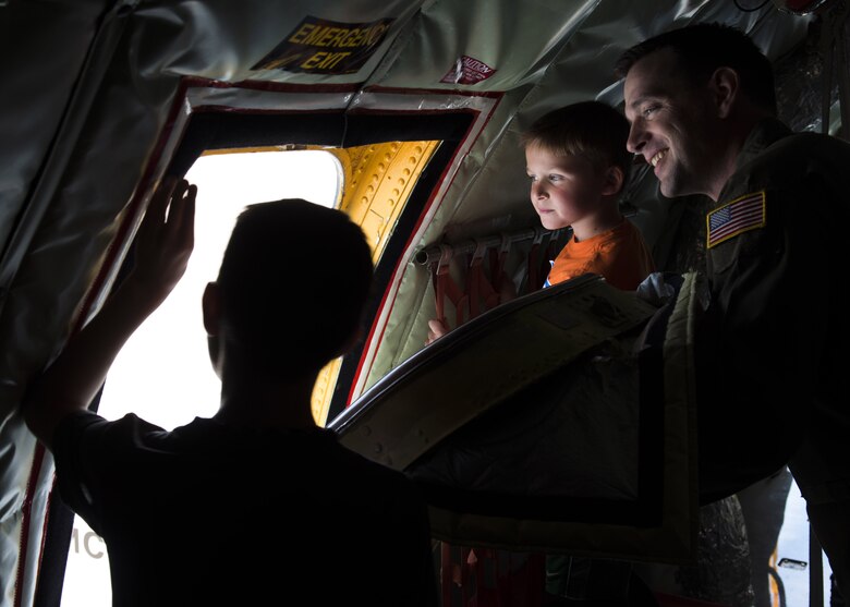 U.S. Air Force Senior Master Sgt. Kevin Wilson, the superintendent assigned to the 97th Training Squadron, and his children look out an emergency exit of a KC-135 Stratotanker, April 26, 2018, at Altus Air Force Base, Okla.