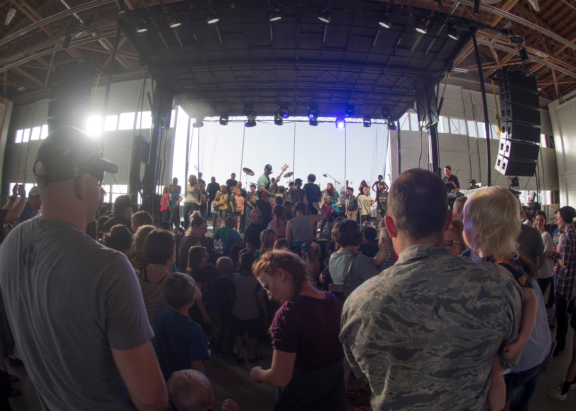 A photo of Gary Sinise, Lt. Dan Band electric bassist, invites children on stage during a song, April 26, 2018, at Mountain Home Air Force Base, Idaho. Approximately 800 military members, veterans, family and friends attended the Lt. Dan Band concert. (U.S. Air Force Photo by Airman First Class Hailey Bivens)