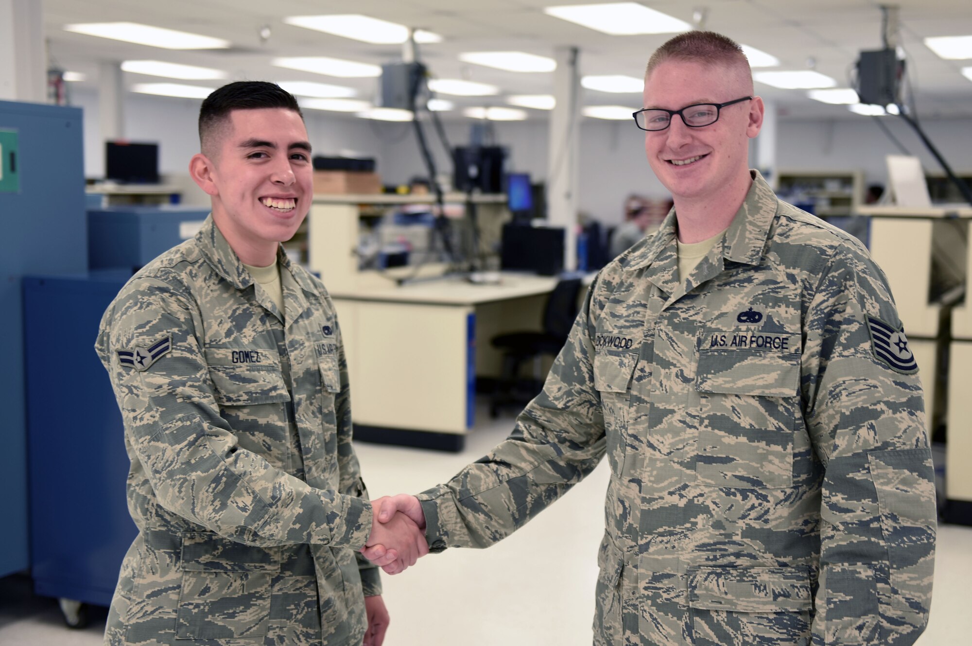 Airman 1st Class Adrian Gomez, 60th Maintenance Squadron precision measurement equipment laboratory technician, stands with his supervisor, Tech Sgt. Benjamin Lockwood, 60th MXS WaveformAnalysis non-commissioned officer in charge, May 2 at Travis Air Force Base, Calif. Lockwood says that despite the language barrier between Gomez and other Airmen in the PMEL flight, Gomez gets along with everyone he works with and maintains a diligent and meticulous work ethic. (U.S. Air Force photo by Airman 1st Class Christian Conrad)