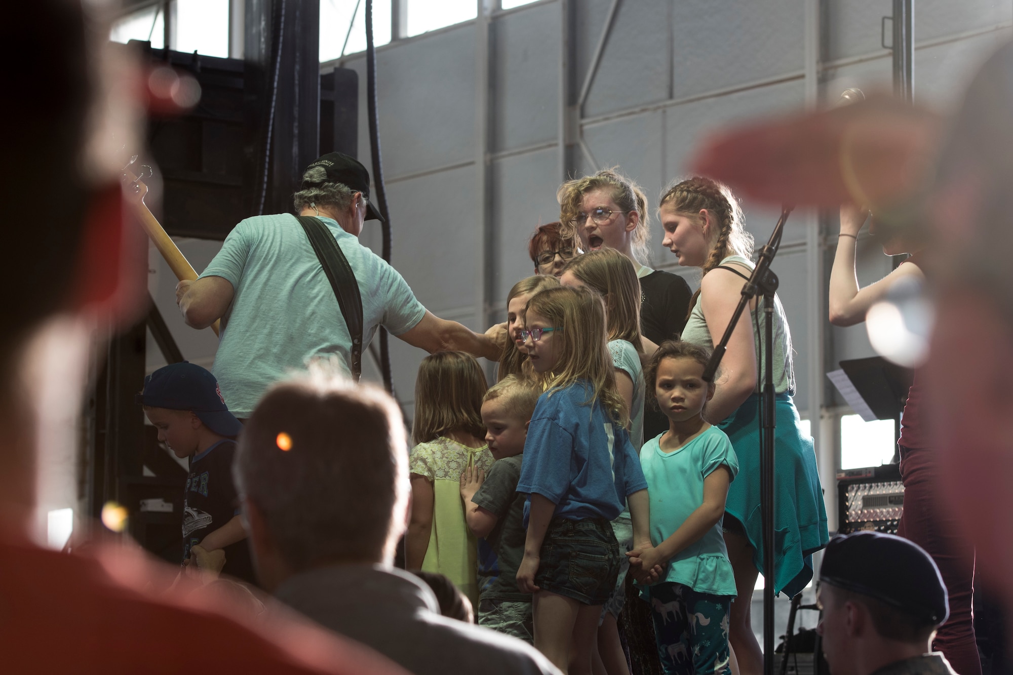 A photo of Gary Sinise, Lt. Dan Band electric bassist, interacts with children on stage during a performance, April 26, 2018, at Mountain Home Air Force Base, Idaho. Approximately 800 military members, veterans, family and friends attended the Lt. Dan Band concert. (U.S. Air Force Photo by Airman 1st Class Hailey Bivens)