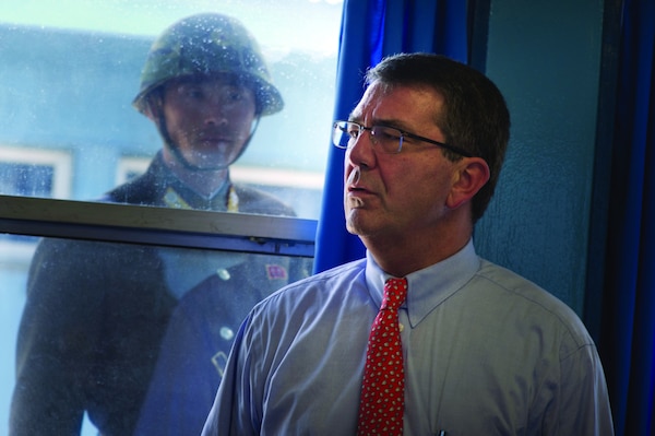 U.S. Deputy Secretary of Defense Ashton B. Carter, right, tours the Military Armistice Commission Building in Panmunjom, South Korea, in the demilitarized zone separating North and South Korea July 26, 2012, as a North Korean soldier watches. Carter wrapped up a 10-day Asia-Pacific trip visiting partners in Hawaii, Guam, Japan, Thailand, India and South Korea. (DoD photo by Mass Communication Specialist 1st Class Chad J. McNeeley, U.S. Navy/Released)