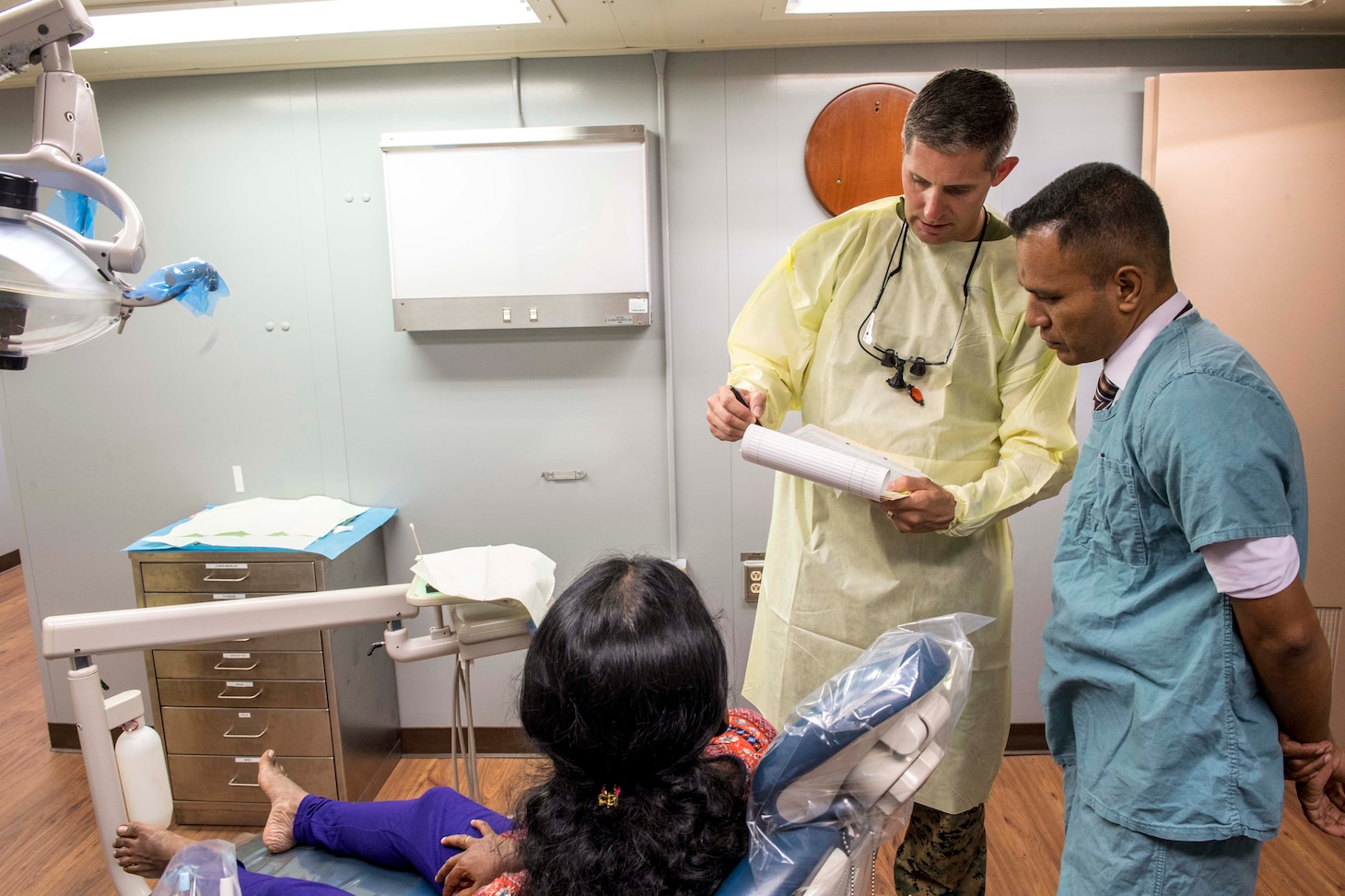 Lt. Lee Atkinson (left), a native of Yuma, Ariz., assigned to Military Sealift Command hospital ship USNS Mercy (T-AH 19) for Pacific Partnership 2018 (PP18), and Dr. Ehiya Mohamed Rizwan (right), a Sri Lankan dentist, go over a patient's care plan prior to performing a dental examination aboard Mercy. PP18's mission is to work collectively with host and partner nations to enhance regional interoperability and disaster response capabilities, increase stability and security in the region, and foster new and enduring friendships across the Indo-Pacific Region. Pacific Partnership, now in its 13th iteration, is the largest annual multinational humanitarian assistance and disaster relief preparedness mission conducted in the Indo-Pacific.