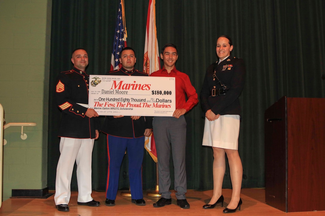 Capt. Jennifer Mozzetta, executive officer, Recruiting Station Tampa, SSgt. Brenton Spriggs (left), station commander, Recruiting Substation Leesburg and Sgt. Gabriel Osorio, canvassing recruiter, present Daniel Moore, a senior at Lake Minneola High School, Minneola, Fl., the Naval Reserve Officer Training Corps Marine Option Scholarship during an awards ceremony May 2, 2018. Moore will be granted the opportunity to serve his country as a Marine Corps officer upon completion of his degree. (Official Marine Corps photo by Sgt. Calvin Shamoon/ Released)