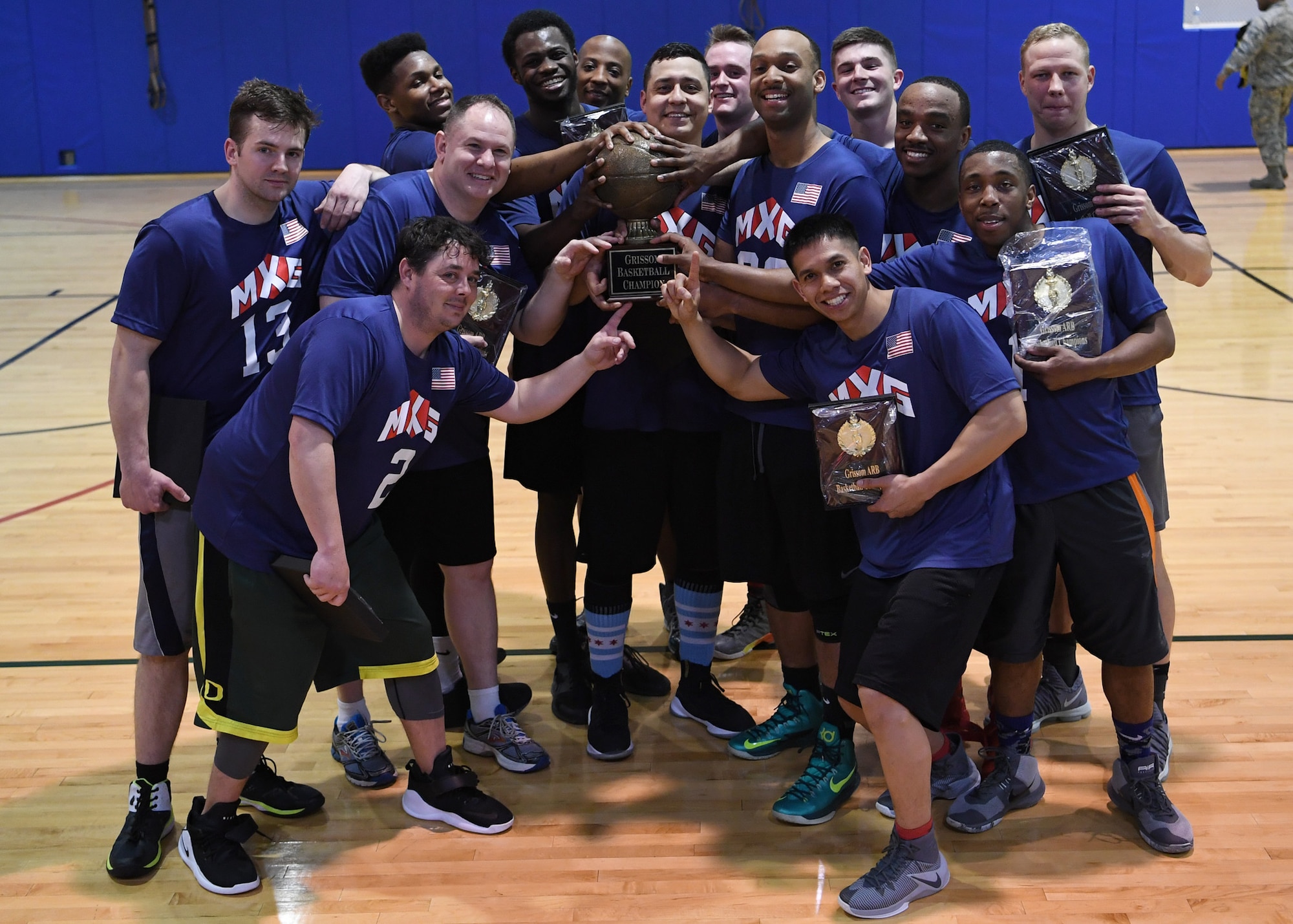Members of the 434th Maintenance Group celebrate outgunning the 434th Security Forces Squadron during Grissom's annual basketball tournament April 7, 2018. The maintainers locked up the title by downing the defenders 36-28. (U.S. Air Force photo/Staff Sgt. Katrina HEIKKINEN)