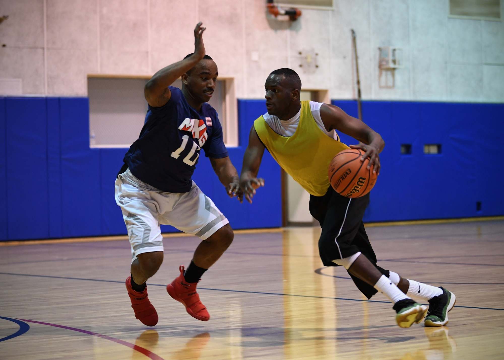 Clifton Wheeler, 434th Security Forces Squadron, right, dribbles around Christopher Pledger, 434th Maintenance Group, during the annual basketball championship at Grissom Air Reserve Base, Ind., April 7, 2018. The Maintainers handcuffed the defenders 36-28 to claim the hardwood crown. (U.S. Air Force photo/Staff Sgt. Katrina HEIKKINEN)