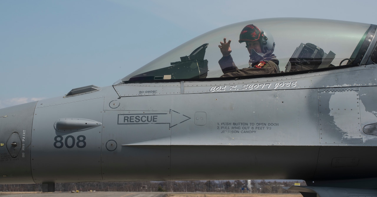 U.S. airman sits in F-16 cockpit.