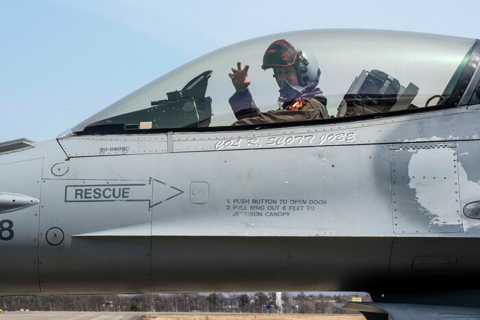 An airman sits in the cockpit of an aircraft.