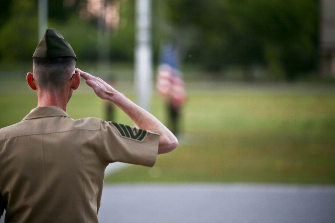 A Marine salutes the flag during evening colors aboard Marine Corps Air Station Beaufort, April 16. The hoisting and lowering of colors is a daily tradition in the Marine Corps where the base renders proper respect and courtesy to the national ensign. The
national ensign is a physical representation of the country and is considered a living thing. It is a universal custom to display the colors from sunrise to sunset.