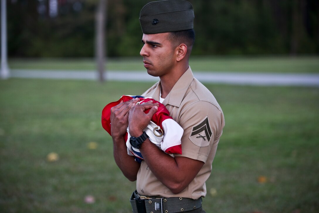A Marine carries the flag after evening colors aboard Marine Corps Air Station Beaufort, April 16. The hoisting and lowering of colors is a daily tradition in the Marine Corps
where the base renders proper respect and courtesy to the national ensign. The national ensign is a physical representation of the country and is considered a living thing.
It is a service wide custom to display the colors from sunrise to sunset.