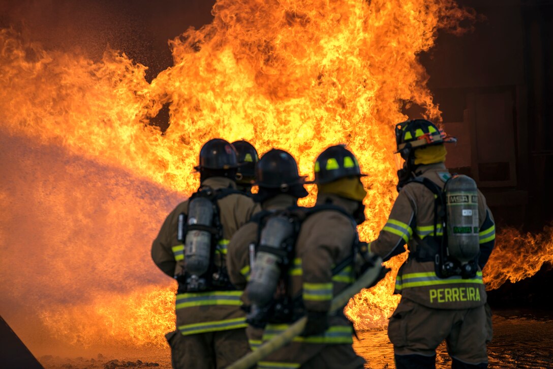 Airmen firefighters extinguish an aircraft fire during an exercise.
