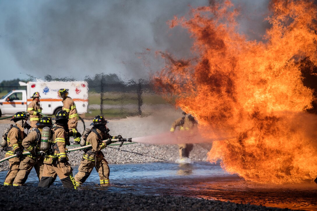 Airmen and firefighters from the Valdosta Fire Department extinguish an aircraft fire.