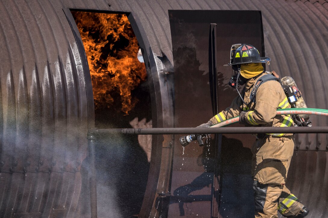 A firefighter enters a simulated aircraft during a training.