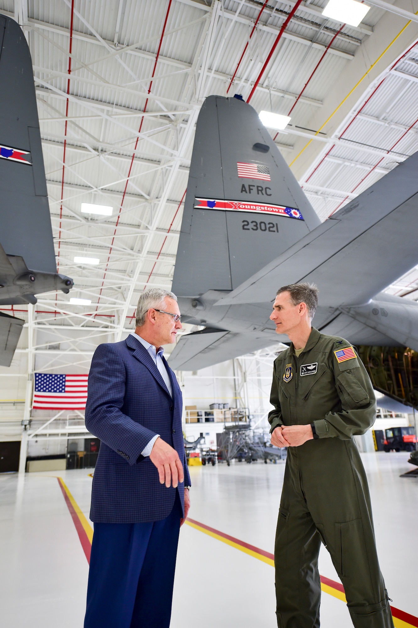 Youngstown State University President Jim Tressel and 910th Airlift Wing Commander Dan Sarachene talk near a pair of C-130H Hercules aircraft here, May 3, 2018, after a ceremony to unveil a new aircraft tail flash and nose art.