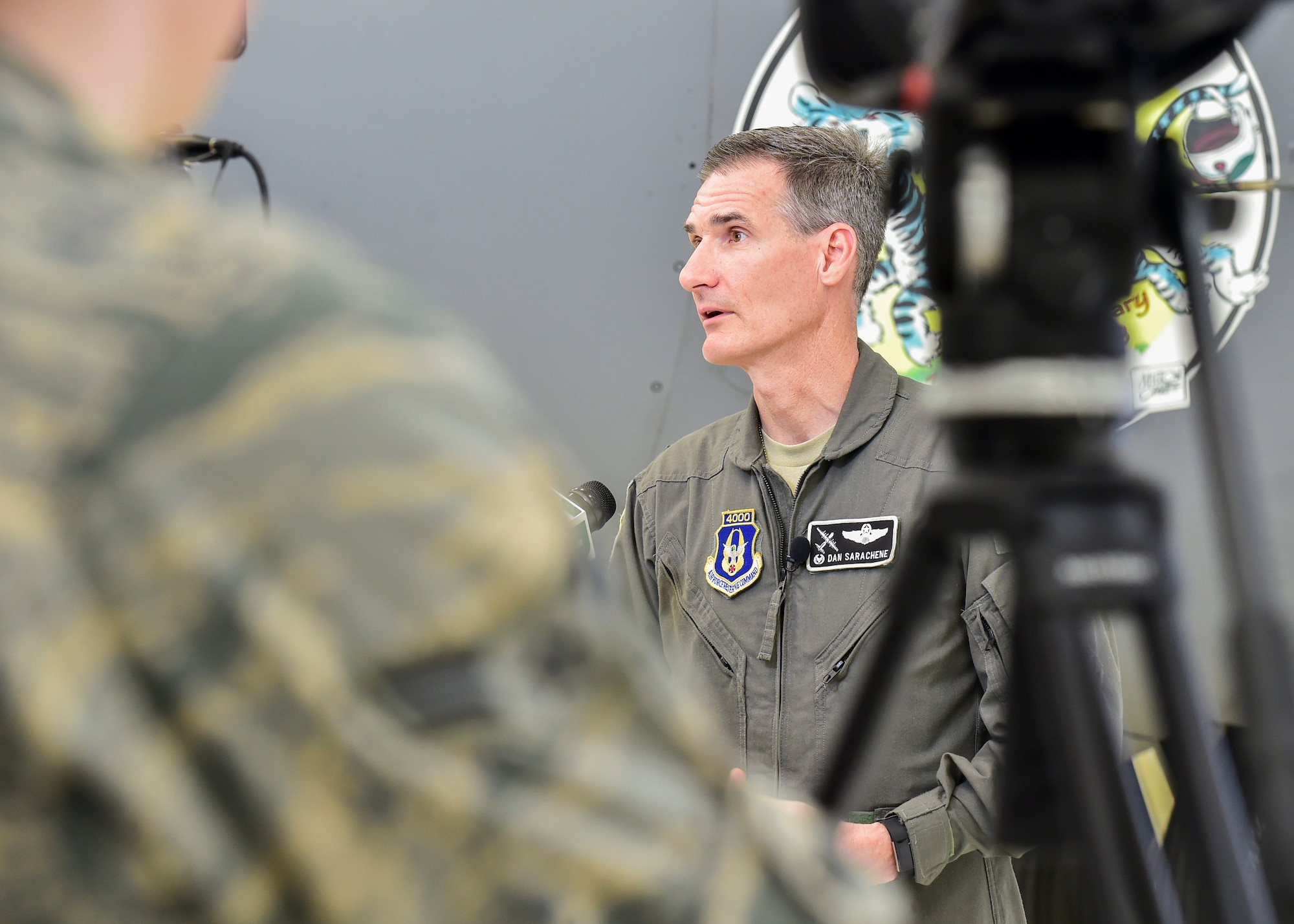 910th Airlift Wing Commander Col. Dan Sarachene talks with a local reporter May 3, 2018, after a ceremony to unveil a new aircraft tail flash and nose art.