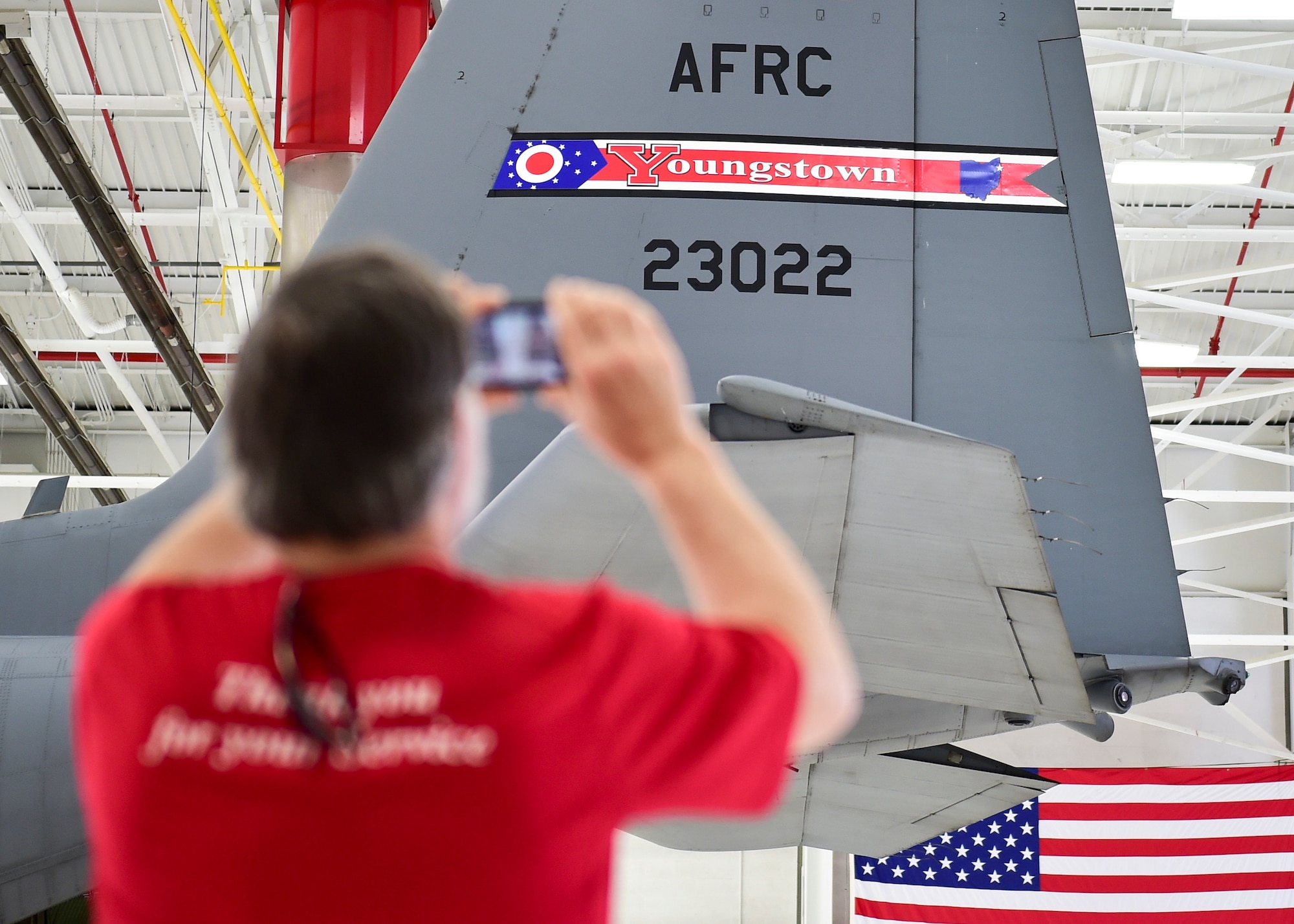 Dave Deibol, a member of the Youngstown Air Reserve Base-Community Council and honorary 910th Operations Group commander, takes a photo of the new Youngtown Air Reserve Station tail flash during an unveiling ceremony here, May 3, 2018.