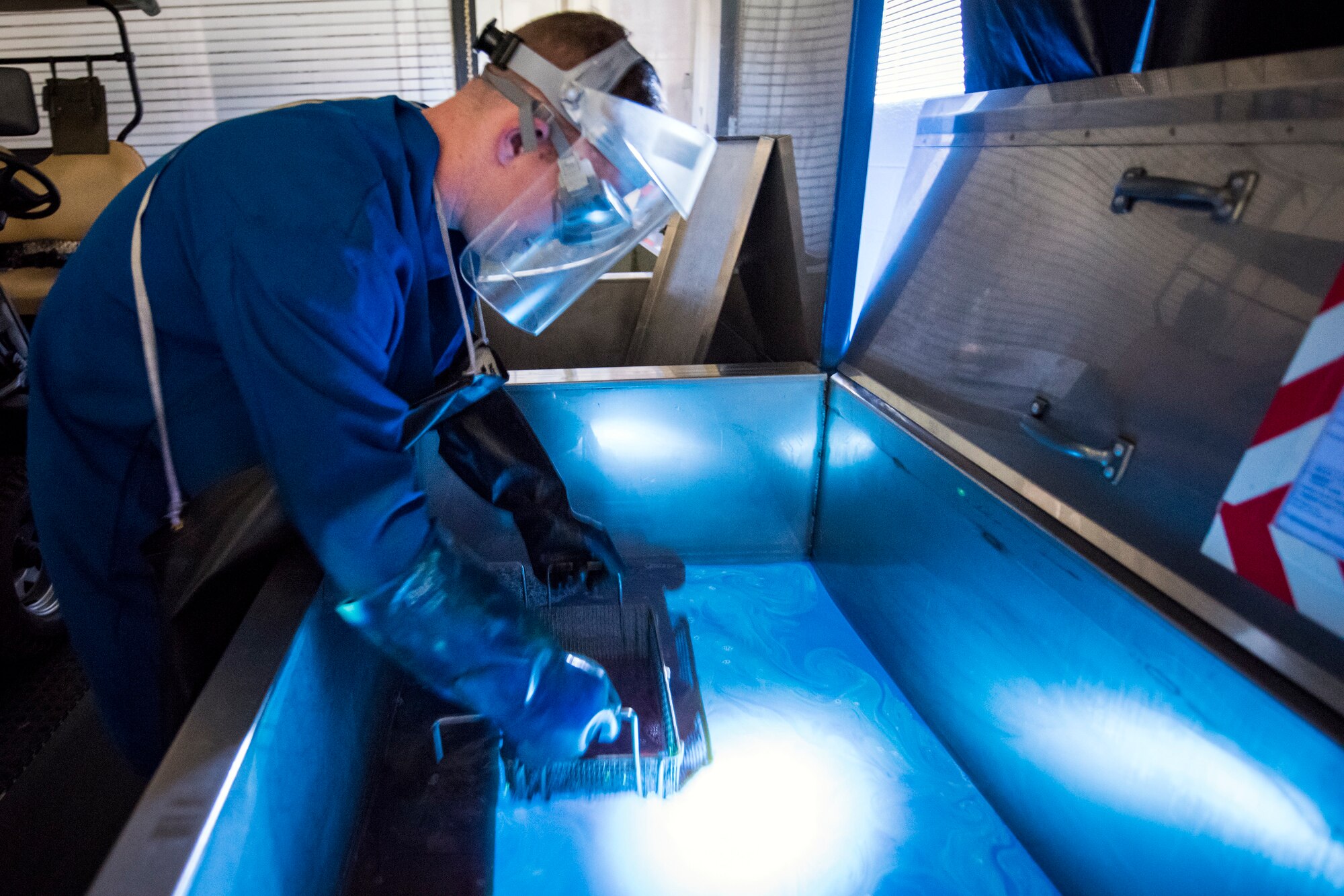 Senior Airman Matthew Horne, 23d Maintenance Squadron non-destructive inspection (NDI) specialist, lifts an aircraft part out of a pool of florescent dye, May 2, 2018, at Moody Air Force Base, Ga. NDI technicians use various methods to complete these inspections such as X-ray, florescent dye penetrant, oil analysis and ultrasonic scanning to examine and inspect numerous aircraft parts and components to ensure that they are in usable condition. (U.S. Air Force photo by Airman 1st Class Eugene Oliver)