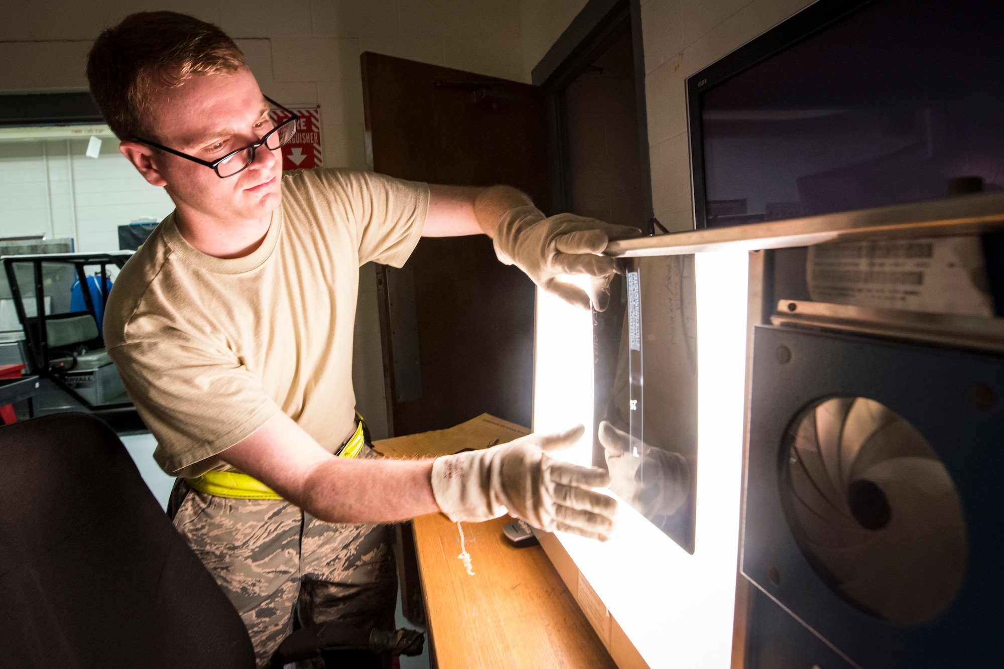 Senior Airman Austin Aldridge, 23d Maintenance Squadron non-destructive inspection (NDI) specialist, aligns film on an X-ray machine, May 2, 2018, at Moody Air Force Base, Ga. NDI technicians use various methods to complete these inspections such as X-ray, florescent dye penetrant, oil analysis and ultrasonic scanning to examine and inspect numerous aircraft parts and components to ensure that they are in usable condition. (U.S. Air Force photo by Airman 1st Class Eugene Oliver)