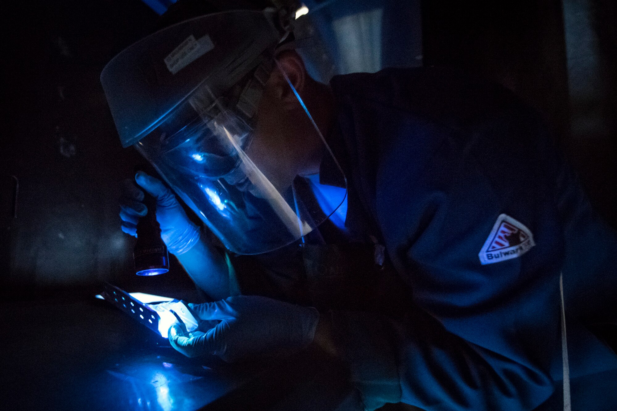 Senior Airman Matthew Horne, 23d Maintenance Squadron non-destructive inspection (NDI) specialist, examines an aircraft part, May 2, 2018, at Moody Air Force Base, Ga. NDI technicians use various methods to complete these inspections such as X-ray, florescent dye penetrant, oil analysis and ultrasonic scanning to examine and inspect numerous aircraft parts and components to ensure that they are in usable condition. (U.S. Air Force photo by Airman 1st Class Eugene Oliver)