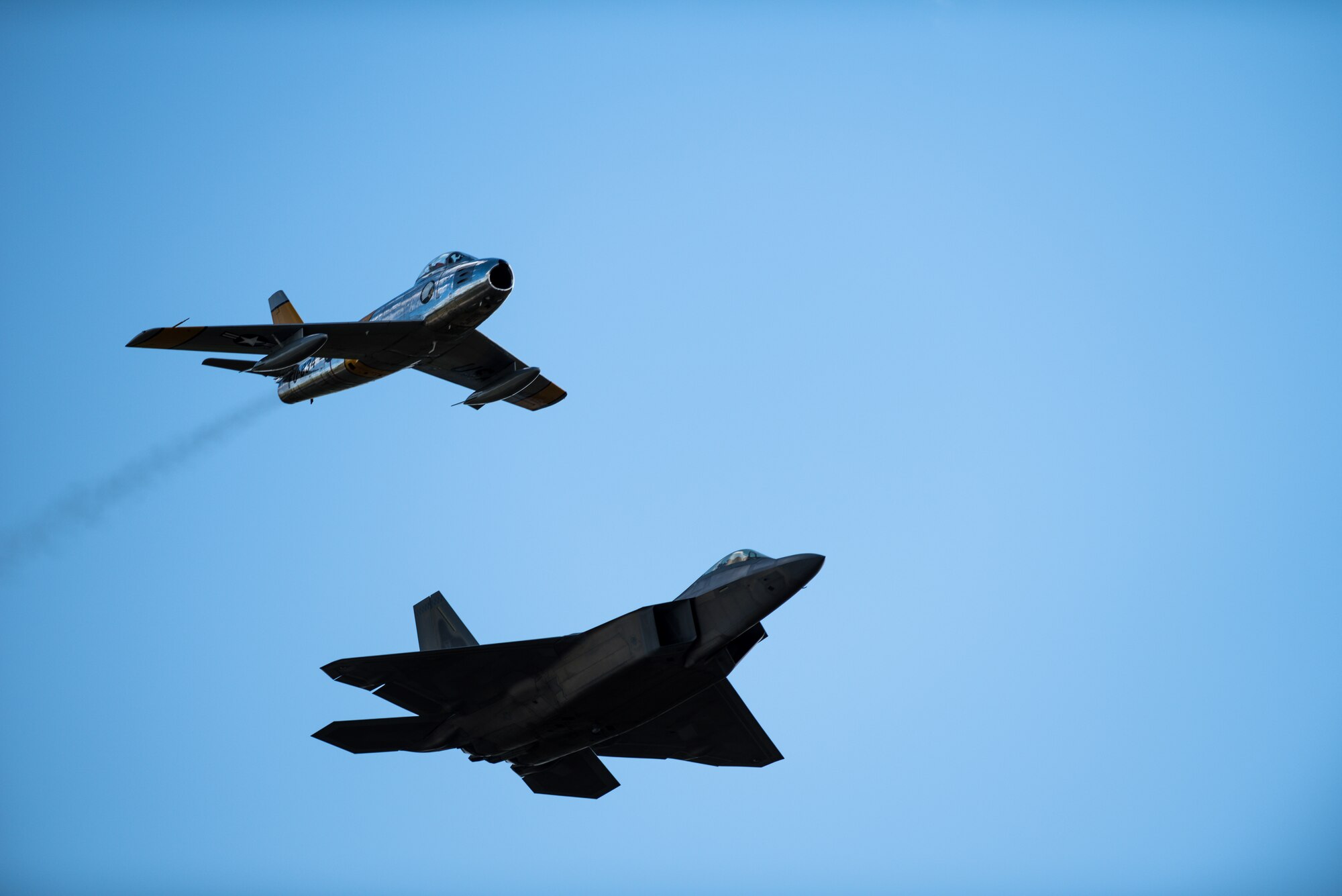 A F-86 Sabre and F-22 Raptor fly in formation during a heritage flight at the Air and Space Expo at Beale Air Force, California, April 27, 2018. The F-86 was the first swept wing fighter aircraft in the Department of Defense and was officially operated by the Air Force in 1949.(U.S Air Force photo/Senior Airman Justin Parsons)