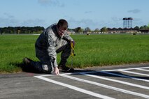 Staff Sgt. Andrew Rodman, 48th Logistics Readiness Squadron training and validation office examiner, measures the lines of a vehicle training course during an inspection at Royal Air Force Mildenhall, England, April 26, 2018. The inspection verified procedures and the course layout to be used for a commercial driver’s licensure program.  (U.S. Air Force photo/Senior Airman Abby L. Finkel)