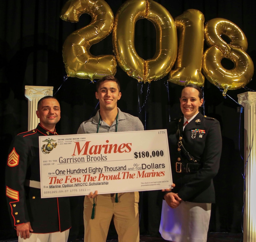 Capt. Jennifer Mozzetta (right), executive officer, Recruiting Station Tampa and SSgt. Brenton Spriggs (left), station commander, Recruiting Substation Leesburg , present Garrison Brooks, a senior at Eustis High School, Eustis, Fl., the Naval Reserve Officer Training Corps Marine Option Scholarship during an awards ceremony May 3, 2018. Brooks will be granted the opportunity to serve his country as a Marine Corps officer upon completion of his degree. (Official Marine Corps photo by Sgt. Shamoon/ Released)