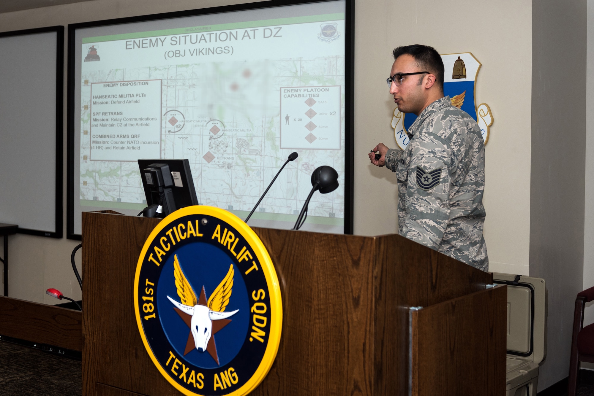 U.S. Air Force Tech. Sgt. Evan Fleming, an operations intelligence craftsman with the 182nd Operations Support Squadron, Illinois Air National Guard, gives a mission briefing to 182nd Airlift Wing aircrews at Naval Air Station Joint Reserve Base Fort Worth, Texas, April 19, 2018.