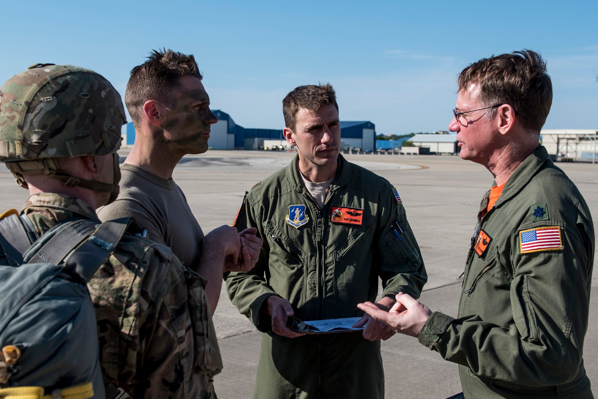 Airmen talking to soldiers on flight line.