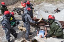 Soldiers from 3rd platoon, 22nd Engineer Clearance Company, work to create wood supports in order to lift the concrete slab off the mannequin during Guardian Response 18 at Muscatatuck Urban Training Center, Indiana on April 22, 2018. The soldiers in the 22nd ECC all have completed a 72-day course at Florida State Fire College in order to be Pro Board certified, a nationally accredited certification in fire services and related fields. The five major disciplines that the soldiers have to learn about are confined space, vehicle machinery rescue, ropes rescue, technology decontamination, and structural collapse. U.S. Army North executes the annual Vibrant Response consequence management exercise at the direction of U.S. Northern Command to confirm command and control elements of the nation’s CBRN response forces. U.S. Force Command’s linked exercise, Guardian Response, held at Muscatatuck Urban Training Center, validates how the subordinate units train to carry out the operations under the direction of a joint task force. GR18 is executed by the U.S. Army Reserve Command. (U.S. Army National Guard photo by Cpl. Elizabeth Scott)