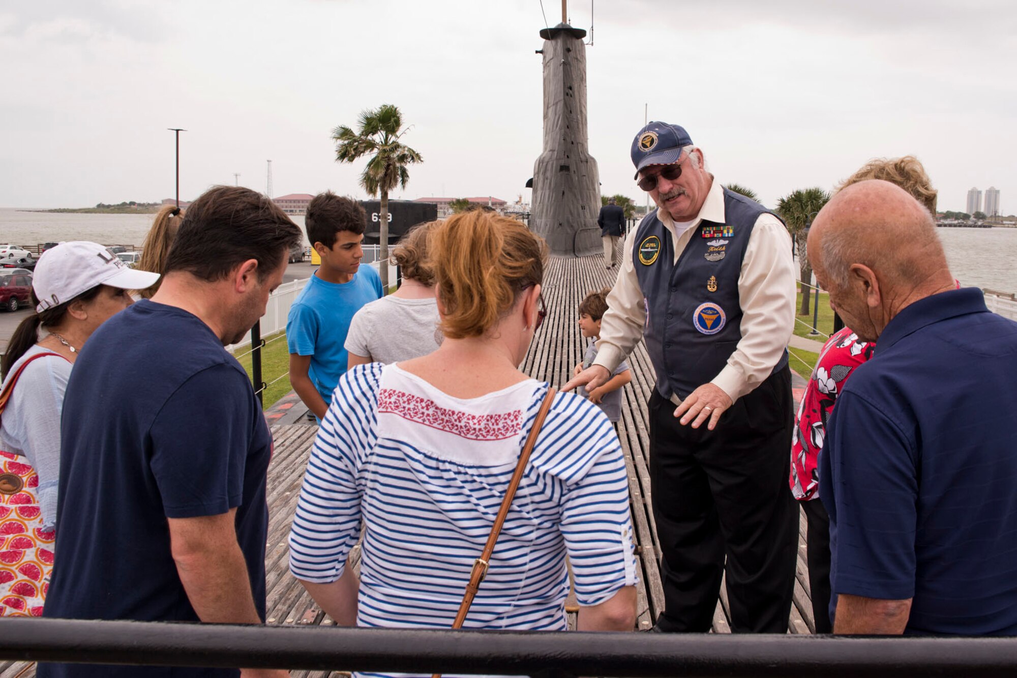 Retired U.S. Navy Sonar Technician, Submarine, Chief (SS) Keith Seiser, explains about decking material, salvage plates, brail markings and the piping underneath the deck of the USS Cavalla (SS 244) for a family visiting Seawolf Park in Galveston, Texas, April 21, 2018.