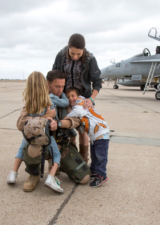 Maj. Michael McMahon, center, an F/A-18C Hornet pilot with Marine Fighter Attack Squadron (VMFA) 314, Marine Aircraft Group 11, 3rd Marine Aircraft Wing, hugs his kids at Marine Corps Air Station Miramar, Calif., after coming home from a six-month deployment May 2. Marines with VMFA-314 returned home following their deployment with Special Purpose Marine Air - Ground Task Force - Crisis Response - Central Command. (U.S. Marine Corps photo by Cpl. Joshua S. McAlpine/Released)