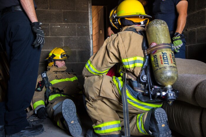 Two newly hired firefighters with Marine Corps Air Station (MCAS) Yuma’s fire department conduct “New Hire Training” at the stations fire department training building aboard MCAS Yuma, Ariz., Tuesday, April 17, 2018. The training teaches new firefighters all the basic skills they need to be successful at their job. This includes: how to climb the ladder, basic EMS training, how to employ and use the fire hose, and rescue drags used for removing civilians from dangerous environments. (U.S. Marine Corps photo by Cpl. Isaac D. Martinez)