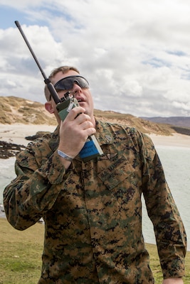 Gunnery Sgt. James Sterling, the staff non-commissioned officer in charge of 4th Air Naval Gunfire Liaison Company, Force Headquarters Group, looks up as he calls in coordinates of a possible target during a practice call-for-fires drill, in Cape Wrath, Scotland,  April, 23, 2018. 4th ANGLICO is in Scotland to take part in Joint Warrior 18-1, an exercise that furthers their readiness and effectiveness in combined arms integration, small unit tactics and land navigation. This training aims at improving their capabilities and combat effectiveness and ensures they're ready to fight tonight.