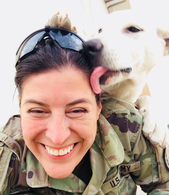 Erby the dog lays a kiss on Army Sgt. Tracy McKithern, a reservist combat photographer with the 982nd Combat Camera Company (Airborne), in the Kurdistan Training Coordination Center near Irbil, Iraq.