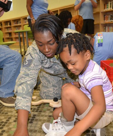 Master Sgt. Lavanna Corbin, 628th Force Support Squadron force management section chief, plays with her daughter Brianna Corbin during a "reveal" celebration as part of the Month of the Military Child at Lambs Elementary School, Charleston, South Carolina, April 13, 2018.