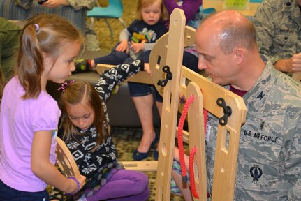 Col. Craig Lambert, 628th Medical Group commander, plays with his daughter Anna, left, during a "reveal" celebration as part of the Month of the Military Child at Lambs Elementary School, Charleston, South Carolina, April 13, 2018.