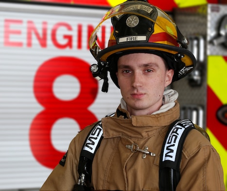 Senior Airman Alex J. Lane, an aircraft rescue firefighter assigned to the 157th Air Refueling Wing Fire Department, poses for a portrait behind a fire engine on May 4, 2018 at Pease Air National Guard Base, N.H. Lane has been a member of the Wing since 2014. (N.H. Air National Guard photo by Staff Sgt. Kayla White)