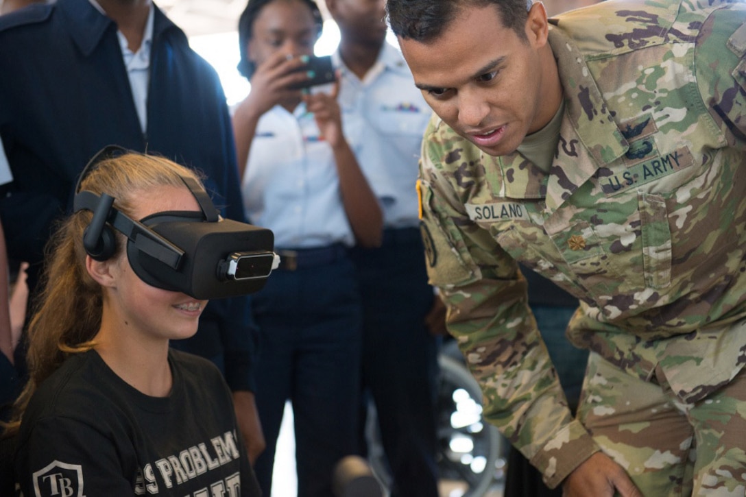 Army Maj. Robert Solano, with U.S. Special Operations Command Special Operations Forces Acquisition, Technology and Logistics directorate, demonstrates an MH-47 Chinook helicopter virtual trainer during Science, Technology, Engineering and Mathematics Day at MacDill Air Force Base in Tampa, Fla.