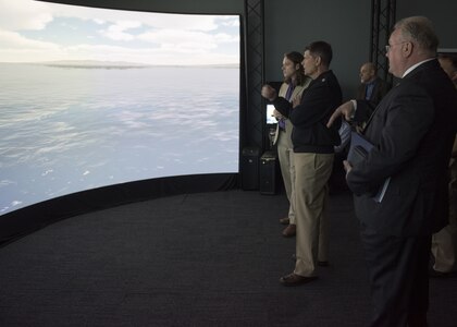 Naval Surface Warfare Center Panama City Division Scientist Jim Perkins, right, briefs Vice Chief of Naval Operations Adm. Bill Moran, USN, on the Smart Mining Initiative (SMI) project using the Computer Assisted Virtual Environment (CAVE) May 3, 2018 in Panama City, Florida. Moran visited the research, development, test and evaluation command May 3, 2018 to learn more about their mission area support to the U.S. Navy. (RELEASED) U.S. Navy photo by Ron Newsome, NSWC PCD.