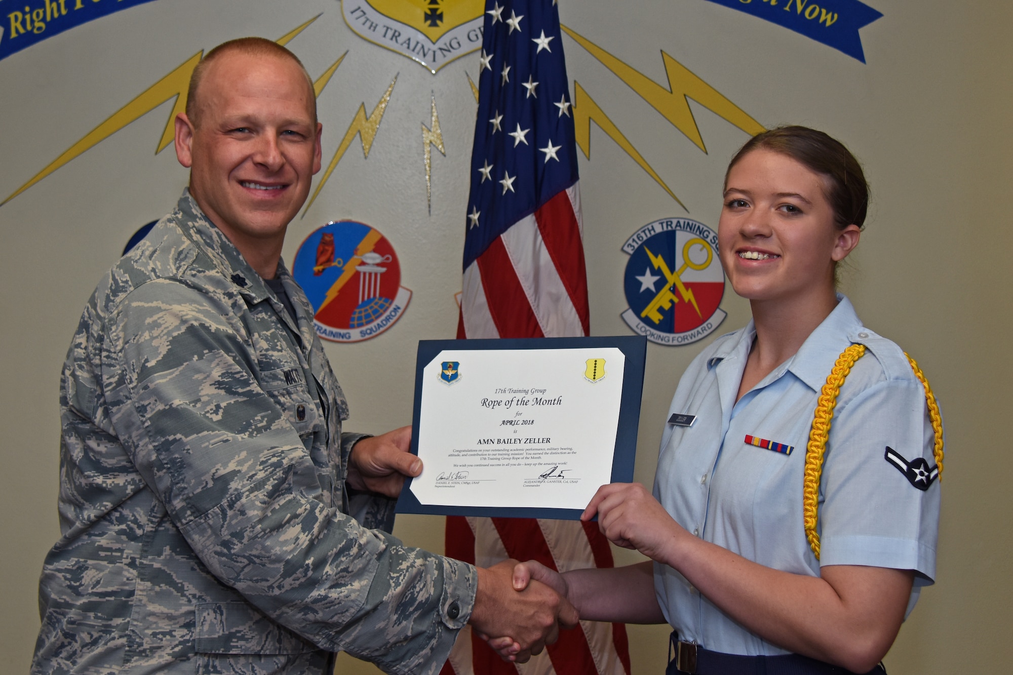U.S. Air Force Lt. Col. Steven Watts, 17th Training Group deputy commander, presents the 17th TRG Rope of the Month award to Airman Bailey Zeller, 315th Training Squadron trainee, at Brandenburg Hall on Goodfellow Air Force Base, Texas, May 4, 2018. The 315th TRS’s vision is to develop combat-ready intelligence, surveillance and reconnaissance professionals and promote an innovative squadron culture and identity unmatched across the U.S. Air Force. (U.S. Air Force photo by Airman 1st Class Zachary Chapman/Released)