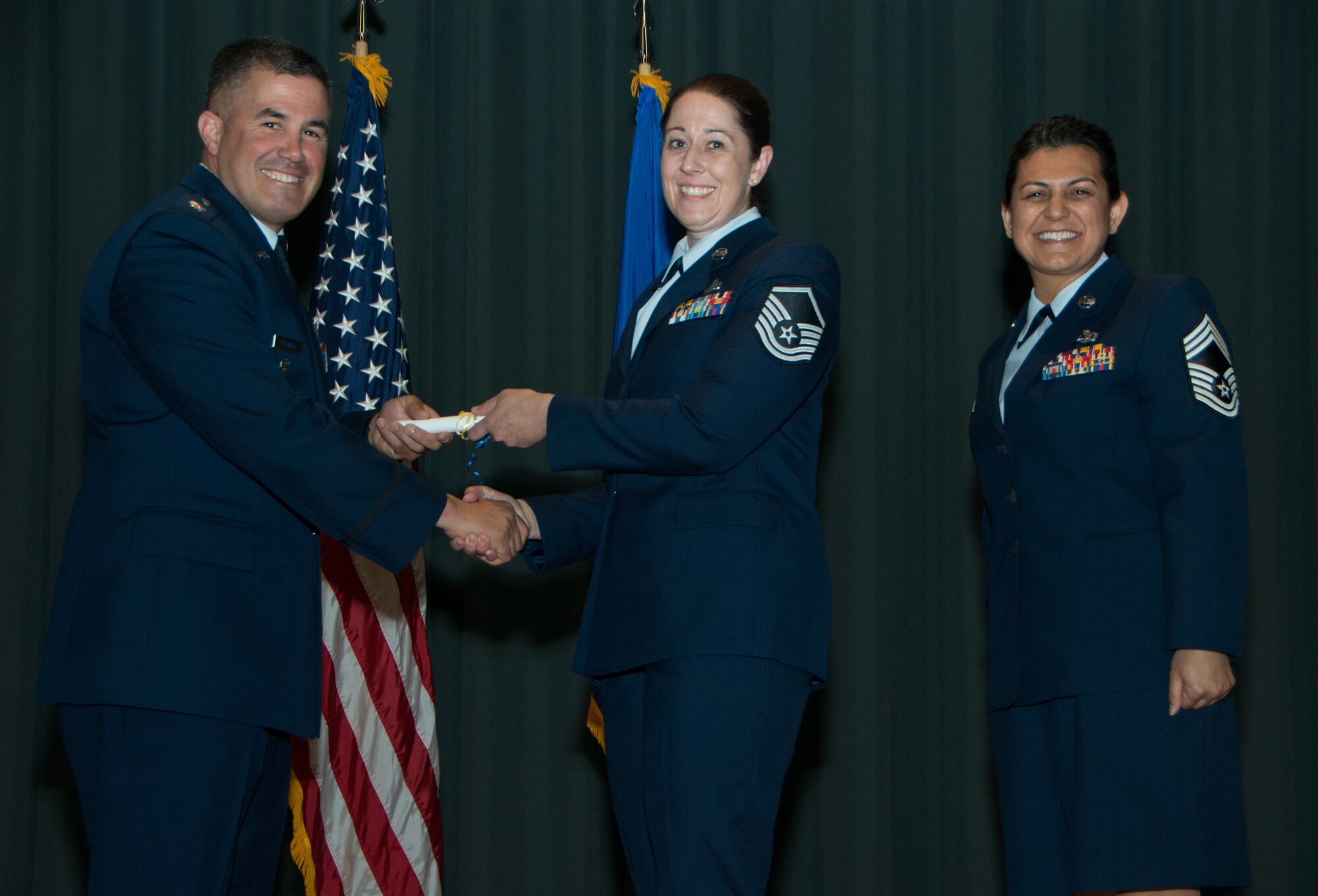 Master Sgt. Dianna Alcocer, 349th Security Forces Squadron, recieves her Community College of the Air Force diploma from Lt. Col. Andrew Frankel, 349 Mission Support Group commander, and Chief Master Sgt. Teresa Serrano, 349th MSG superintendant, during a CCAF graduation ceremony May 4, 2018 at Travis Air Force Base, Calif. Alcocer recieved her associate's degree in criminal justice. (U.S. Air Force photo/Staff Sgt. Daniel Phelps)