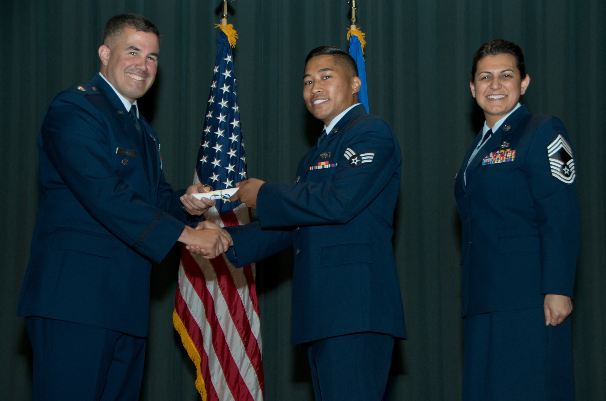 Senior Airman Jon Erwin Antes, 23d Combat Communication Squadron, recieves his Community College of the Air Force diploma from Lt. Col. Andrew Frankel, 349th Mission Support Group commander, and Chief Master Sgt. Teresa Serrano, 349th MSG superintendant, during a CCAF graduation ceremony May 4, 2018 at Travis Air Force Base, Calif. Antes recieved his associate's degree in Information technology. (U.S. Air Force photo/Staff Sgt. Daniel Phelps)